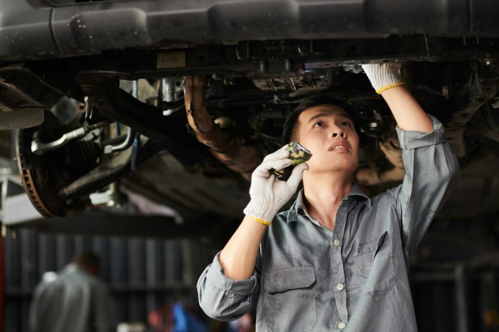 Mechanic Inspecting Suspended Vehicle